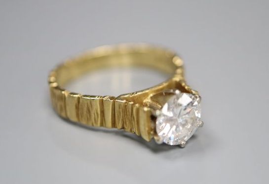A modern textured 18ct gold and solitaire diamond ring, the stone weighing 0.90ct, size L, gross 4.1 grams,